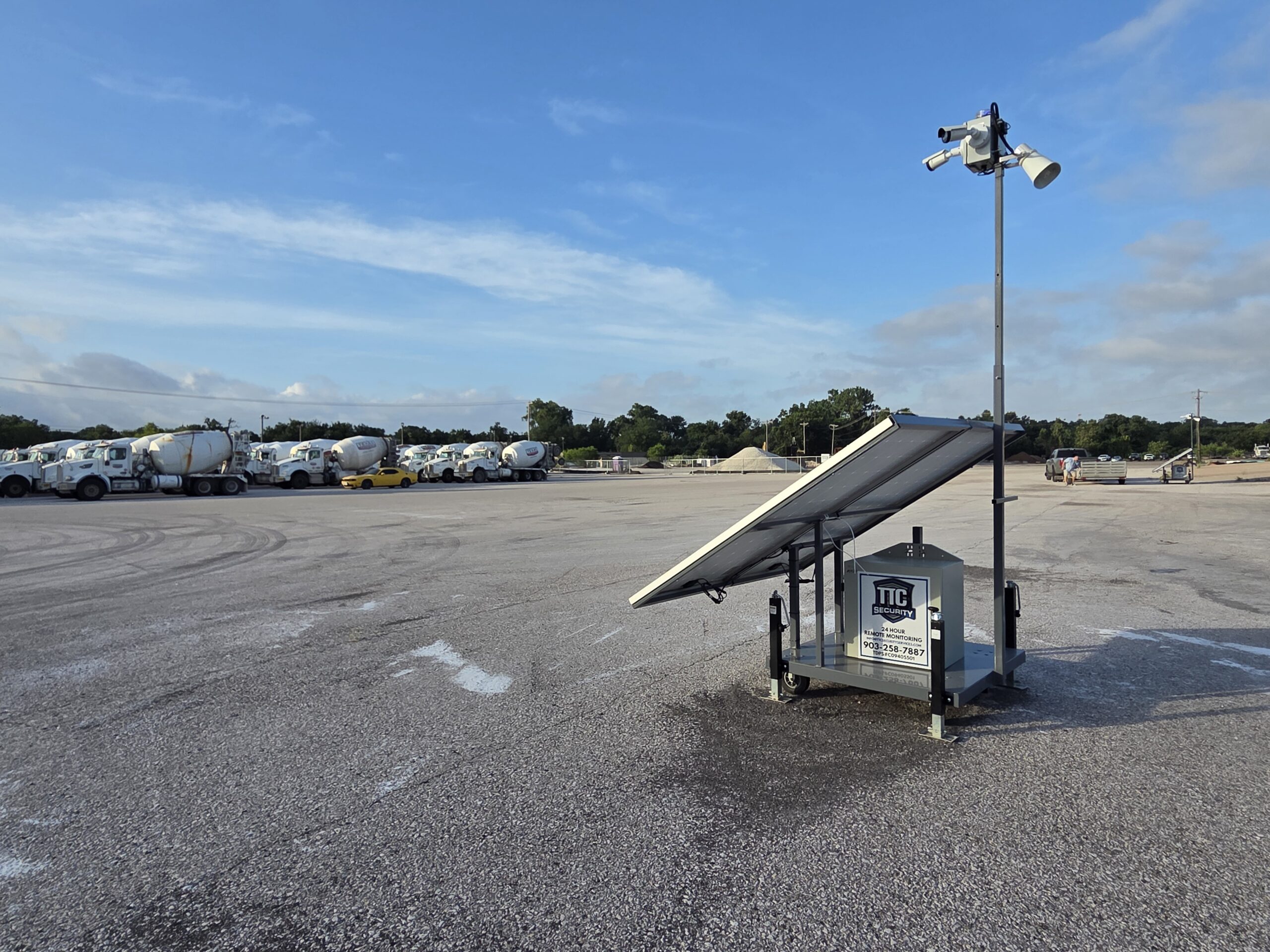 Mobile solar-powered security camera trailer protecting an asphalt plant and heavy equipment yard in Austin, TX with 24/7 remote surveillance.