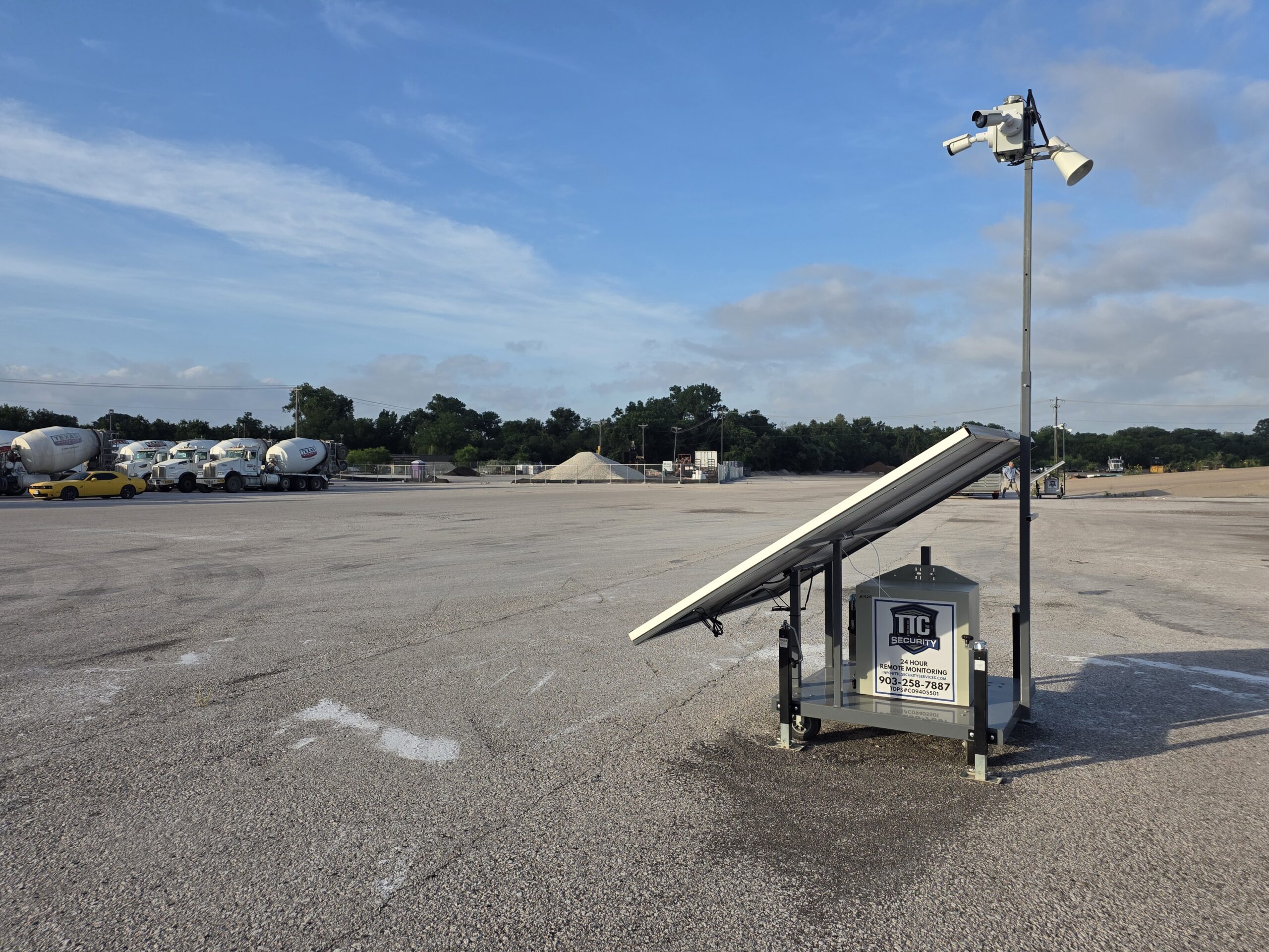 Solar-powered mobile security camera trailer protecting a commercial equipment yard in Dallas, TX with 24/7 remote video monitoring and AI surveillance.